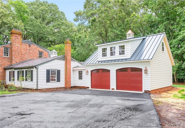 13531 W Salisbury Rd, Midlothian, VA 23113 - view of front of home with a standing seam roof, a garage, asphalt driveway, metal roof, and view of scattered trees