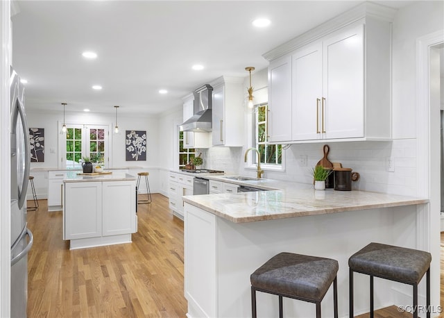 13531 W Salisbury Rd, Midlothian, VA 23113 - kitchen featuring wall chimney range hood, a sink, a peninsula, light wood finished floors, and tasteful backsplash