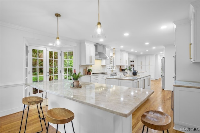 13531 W Salisbury Rd, Midlothian, VA 23113 - kitchen featuring wall chimney exhaust hood, a kitchen island, light wood-style flooring, a kitchen bar, and recessed lighting