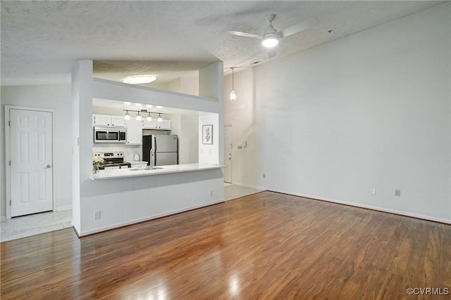 10205 Wolfe Manor Ct Unit 1012, Glen Allen, VA 23060 - unfurnished living room featuring a ceiling fan, wood finished floors, vaulted ceiling, a textured ceiling, and baseboards