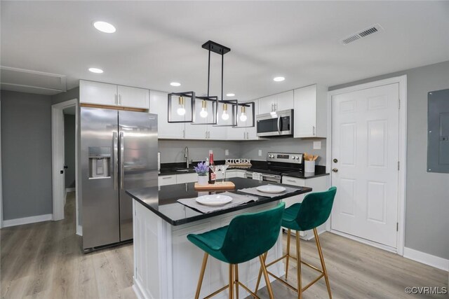 935 Wilcox St, Petersburg, VA 23803 - kitchen with stainless steel appliances, light wood finished floors, white cabinets, and recessed lighting
