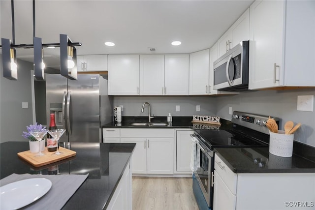 935 Wilcox St, Petersburg, VA 23803 - kitchen featuring stainless steel appliances, a sink, dark countertops, white cabinets, and recessed lighting