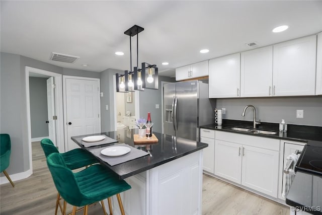 935 Wilcox St, Petersburg, VA 23803 - kitchen with a sink, stainless steel fridge with ice dispenser, range, white cabinetry, and recessed lighting