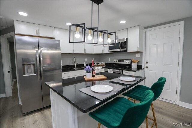 935 Wilcox St, Petersburg, VA 23803 - kitchen with appliances with stainless steel finishes, a sink, light wood-style flooring, white cabinetry, and recessed lighting