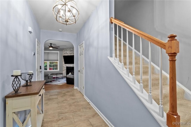 1753 Rose Mill Cir, Midlothian, VA 23112 - foyer entrance featuring a stone fireplace, a ceiling fan, stairway, and arched walkways