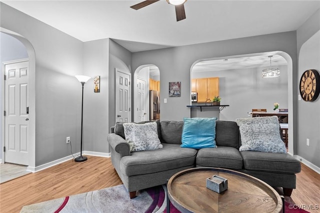 1753 Rose Mill Cir, Midlothian, VA 23112 - living area featuring light wood-style floors, arched walkways, ceiling fan, and baseboards