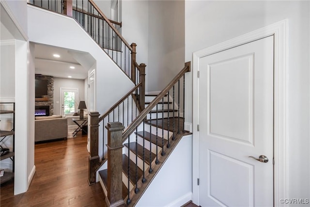 14104 Waters Edge Cir, Midlothian, VA 23112 - stairway with wood finished floors, a stone fireplace, a high ceiling, and recessed lighting