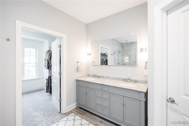 14104 Waters Edge Cir, Midlothian, VA 23112 - bathroom featuring double vanity, a walk in shower, a walk in closet, baseboards, and wood finished floors