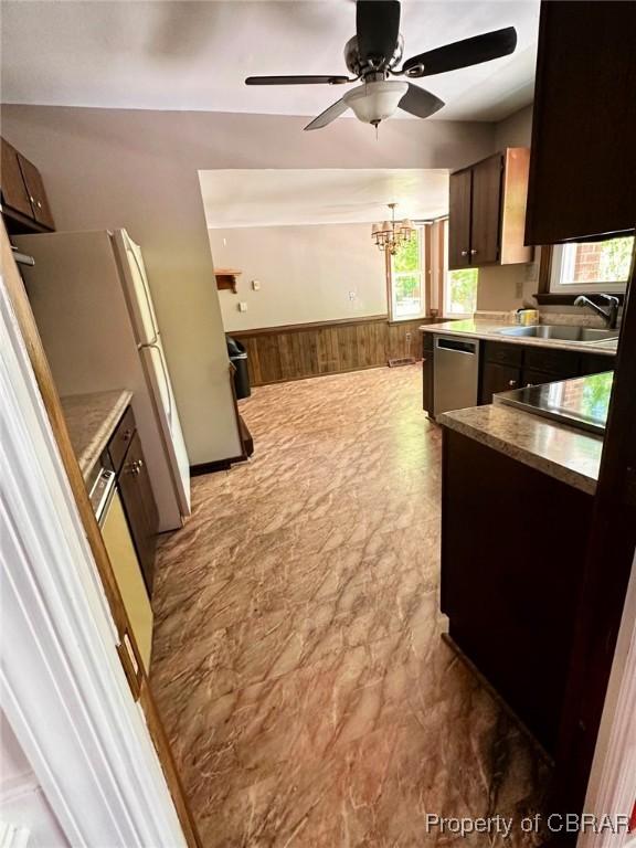 402 N Ivy Ave, Highland Springs, VA 23075 - kitchen with a sink, stainless steel dishwasher, wainscoting, wooden walls, and ceiling fan