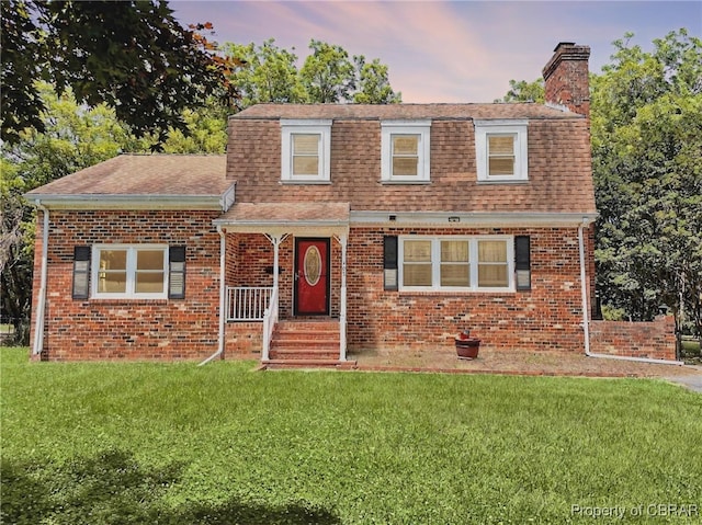 402 N Ivy Ave, Highland Springs, VA 23075 - view of front of house with a front yard, a chimney, brick siding, and a shingled roof