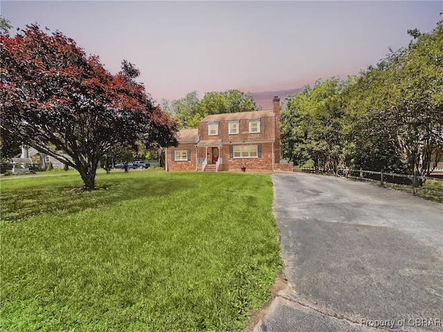 402 N Ivy Ave, Highland Springs, VA 23075 - view of front of home featuring a front lawn, a chimney, brick siding, and driveway
