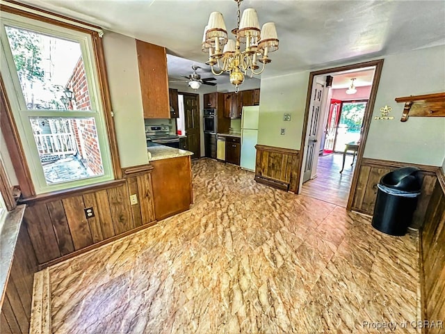 402 N Ivy Ave, Highland Springs, VA 23075 - kitchen with freestanding refrigerator, a wainscoted wall, a chandelier, stainless steel range with electric cooktop, and wood walls