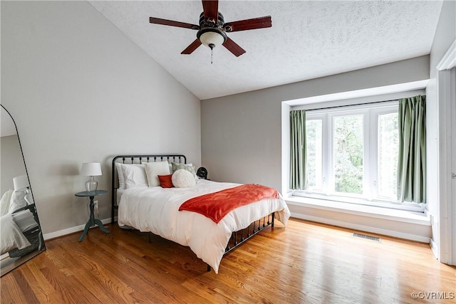 12125 Shore View Dr, Henrico, VA 23233 - bedroom with vaulted ceiling, wood finished floors, a textured ceiling, baseboards, and ceiling fan