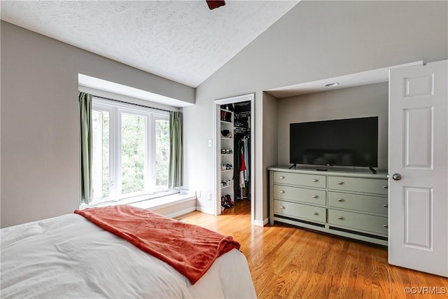 12125 Shore View Dr, Henrico, VA 23233 - bedroom with vaulted ceiling, wood finished floors, a walk in closet, a closet, and a textured ceiling