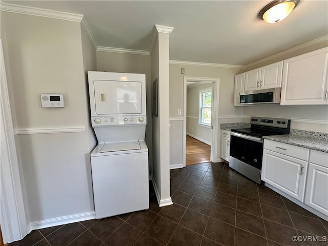 1709 Glenview Rd, Richmond, VA 23222 - kitchen featuring appliances with stainless steel finishes, stacked washing machine and dryer, white cabinets, baseboards, and dark tile patterned flooring