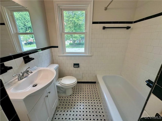 1709 Glenview Rd, Richmond, VA 23222 - bathroom featuring tile walls, toilet, vanity, plenty of natural light, and a wainscoted wall