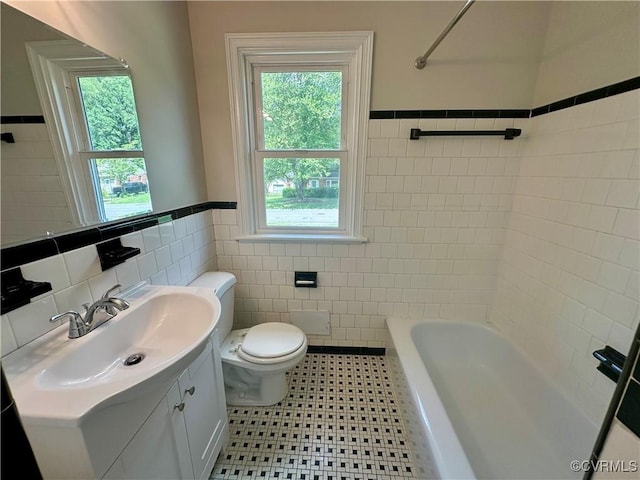 1709 Glenview Rd, Richmond, VA 23222 - full bathroom with tile walls, toilet, healthy amount of natural light, vanity, and wainscoting