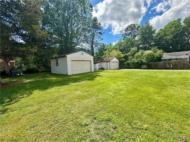 1709 Glenview Rd, Richmond, VA 23222 - view of yard with a garage, an outbuilding, and view of wooded area