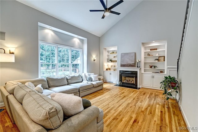3006 Calcutt Dr, Midlothian, VA 23113 - living area featuring light wood-style floors, a ceiling fan, high vaulted ceiling, a high end fireplace, and built in shelves
