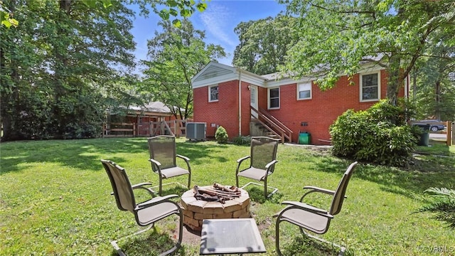 2207 Marroit Rd, Henrico, VA 23229 - view of grassy yard featuring a fire pit, central AC, and stairs