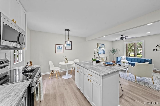 1121 Collingwood Dr, North Prince George, VA 23860 - kitchen featuring appliances with stainless steel finishes, white cabinetry, light wood-style flooring, and light stone countertops