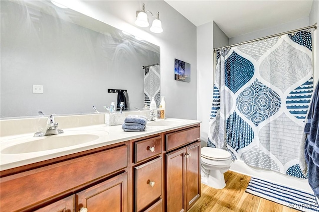 506 N 28th St, Richmond, VA 23223 - full bathroom with double vanity, toilet, and wood finished floors