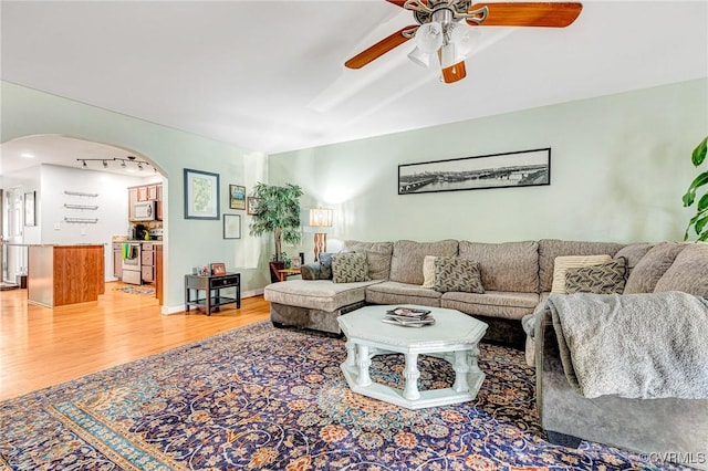506 N 28th St, Richmond, VA 23223 - living area with arched walkways, ceiling fan, and light wood-style floors