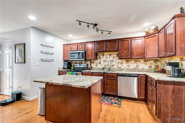 506 N 28th St, Richmond, VA 23223 - kitchen featuring appliances with stainless steel finishes, light wood-style flooring, backsplash, a center island, and recessed lighting