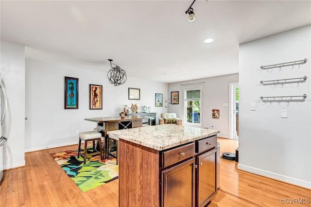 506 N 28th St, Richmond, VA 23223 - kitchen with light wood-style floors, a kitchen island, light stone counters, baseboards, and recessed lighting