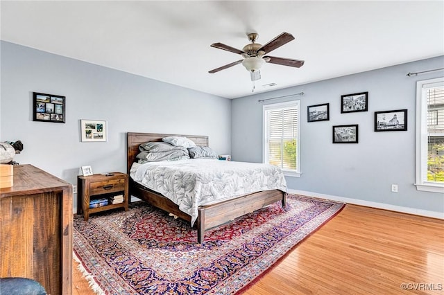 506 N 28th St, Richmond, VA 23223 - bedroom featuring light wood-type flooring, multiple windows, baseboards, and a ceiling fan