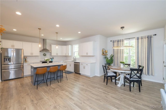 13042 Fieldfare Dr, Midlothian, VA 23112 - kitchen with stainless steel appliances, wall chimney exhaust hood, light countertops, a breakfast bar area, and a center island