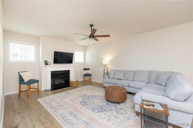 13042 Fieldfare Dr, Midlothian, VA 23112 - living area with ceiling fan, light wood finished floors, a glass covered fireplace, and baseboards