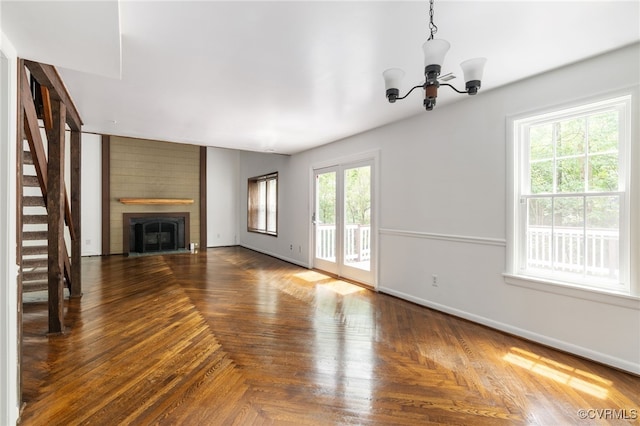 13503 Headwaters Pl, Midlothian, VA 23113 - unfurnished living room with a chandelier, baseboards, stairway, and a large fireplace