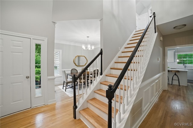 11320 Glendevon Rd, Chesterfield, VA 23838 - foyer entrance with light wood finished floors, a chandelier, stairs, a decorative wall, and a towering ceiling