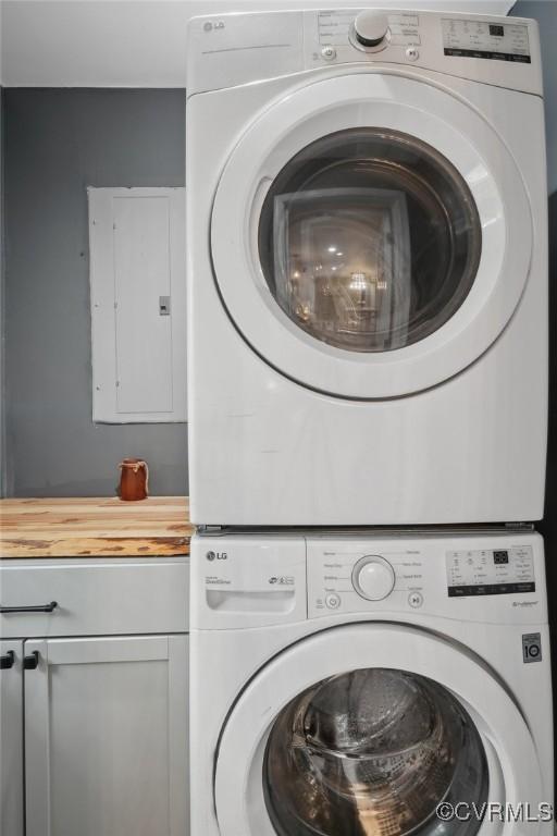 6286 Mcclellan Rd, Mechanicsville, VA 23111 - laundry area featuring stacked washer / drying machine, electric panel, and cabinet space