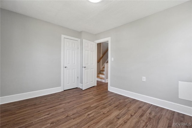 512 St Andrew St, Petersburg, VA 23803 - unfurnished bedroom with dark wood-style flooring, baseboards, and a closet