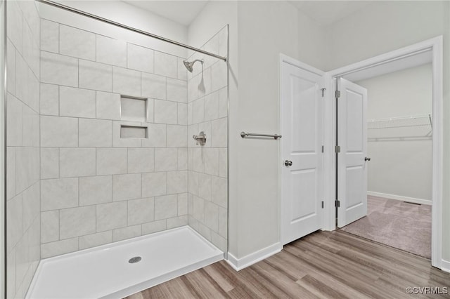 1343 Buckners Ln, Mineral, VA 23117 - full bathroom featuring a tile shower, baseboards, wood finished floors, and a spacious closet