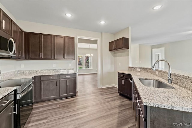1343 Buckners Ln, Mineral, VA 23117 - kitchen featuring stainless steel appliances, a sink, light wood-type flooring, dark brown cabinetry, and light stone counters