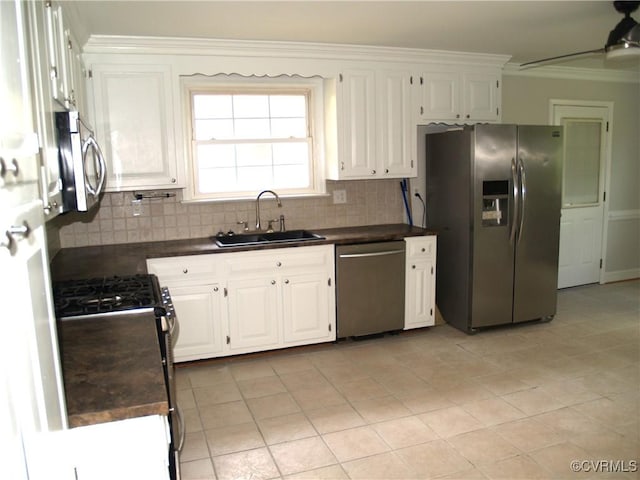 11001 Old Church Rd, New Kent, VA 23124 - kitchen with appliances with stainless steel finishes, a sink, dark countertops, ornamental molding, and white cabinets
