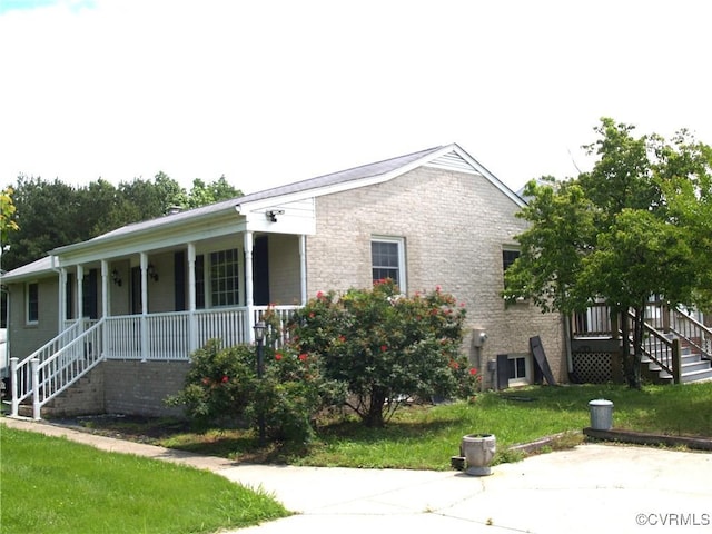 11001 Old Church Rd, New Kent, VA 23124 - view of side of home featuring covered porch, stairs, a lawn, and brick siding