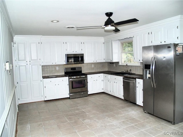 11001 Old Church Rd, New Kent, VA 23124 - kitchen with stainless steel appliances, dark countertops, decorative backsplash, and white cabinets
