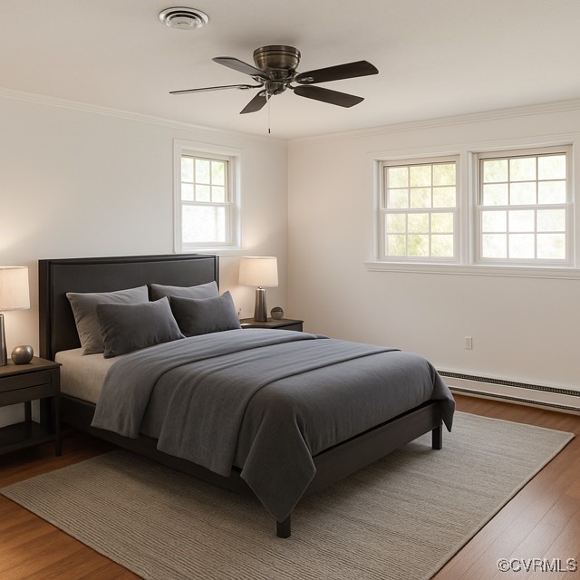 11001 Old Church Rd, New Kent, VA 23124 - bedroom featuring a baseboard heating unit, crown molding, wood finished floors, and a ceiling fan