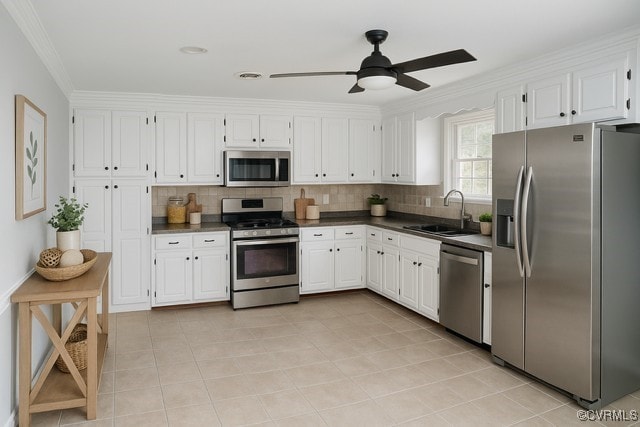 11001 Old Church Rd, New Kent, VA 23124 - kitchen with stainless steel appliances, dark countertops, tasteful backsplash, white cabinetry, and crown molding