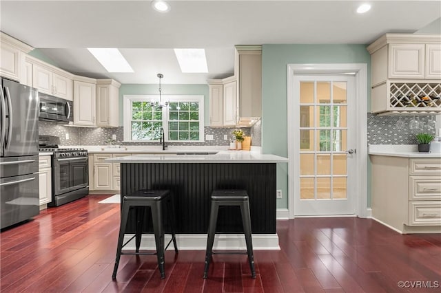 13908 Sunrise Bluff Rd, Midlothian, VA 23112 - kitchen featuring stainless steel appliances, a skylight, light countertops, a kitchen bar, and recessed lighting
