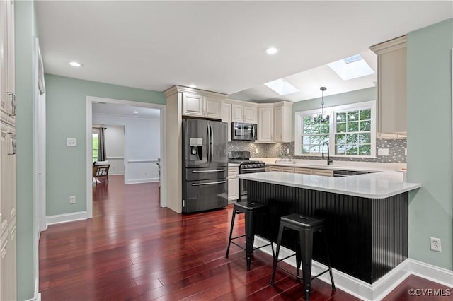 13908 Sunrise Bluff Rd, Midlothian, VA 23112 - kitchen featuring appliances with stainless steel finishes, a skylight, a peninsula, a kitchen breakfast bar, and recessed lighting