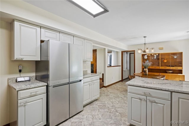 2805 Meeting Gate Ct, Chesterfield, VA 23112 - kitchen with freestanding refrigerator, a chandelier, white cabinets, hanging light fixtures, and light stone counters