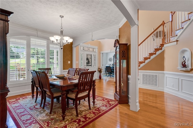 12300 Wynnstay Ln, Chesterfield, VA 23838 - dining room with ornamental molding, a chandelier, light wood-style floors, arched walkways, and a textured ceiling