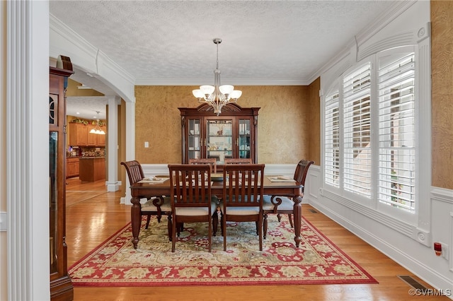 12300 Wynnstay Ln, Chesterfield, VA 23838 - dining space with a chandelier, a textured ceiling, arched walkways, crown molding, and light wood-style floors