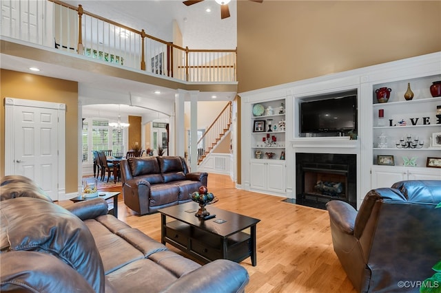 12300 Wynnstay Ln, Chesterfield, VA 23838 - living room featuring ceiling fan, light wood finished floors, a high ceiling, a chandelier, and a fireplace with flush hearth