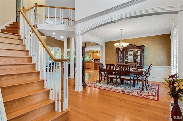 12300 Wynnstay Ln, Chesterfield, VA 23838 - dining space with arched walkways, wood finished floors, a chandelier, stairway, and ornamental molding